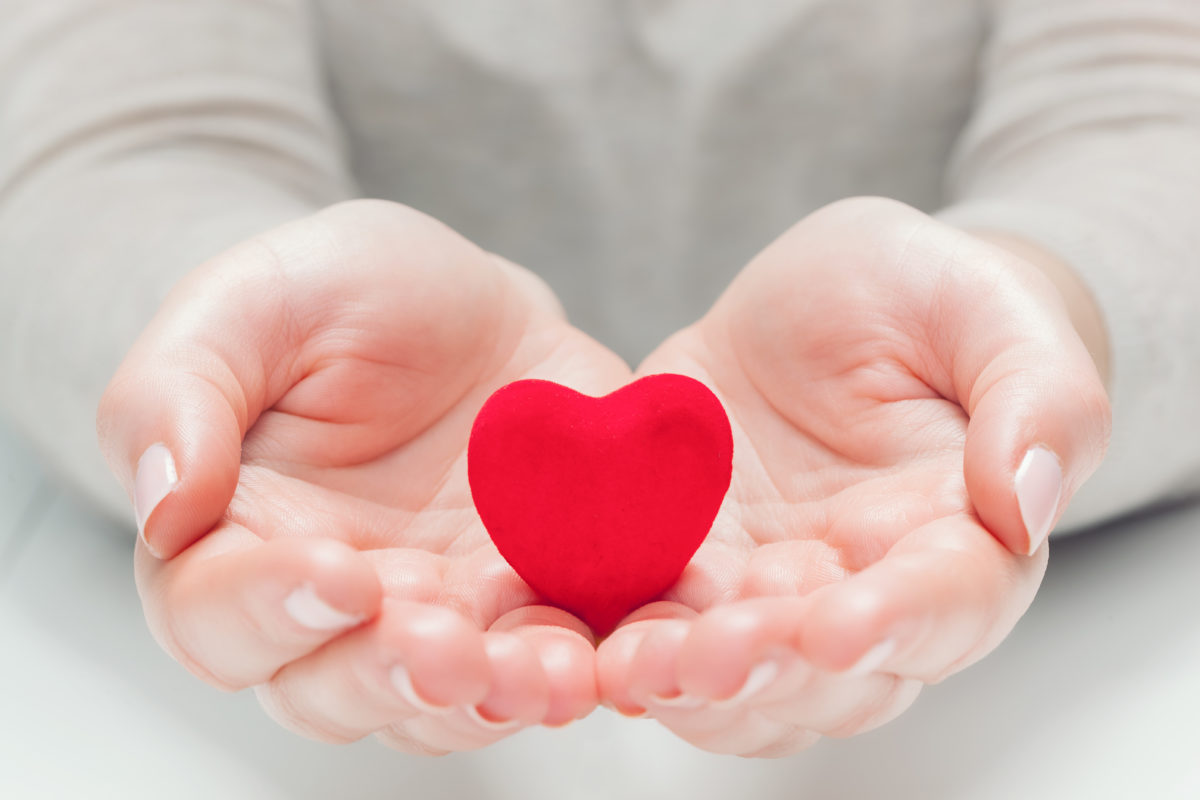 small-red-heart-in-womans-hands-in-a-gesture-of-PEW8YH6-1200x800.jpg